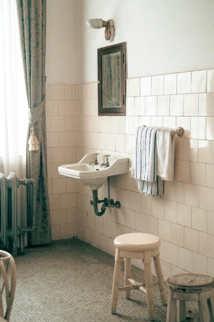 Freshly fitted bathroom with a white basin and tiled wall
